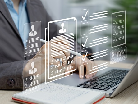 digital application and form images project from a computer screen while a human hand hovers over the projections