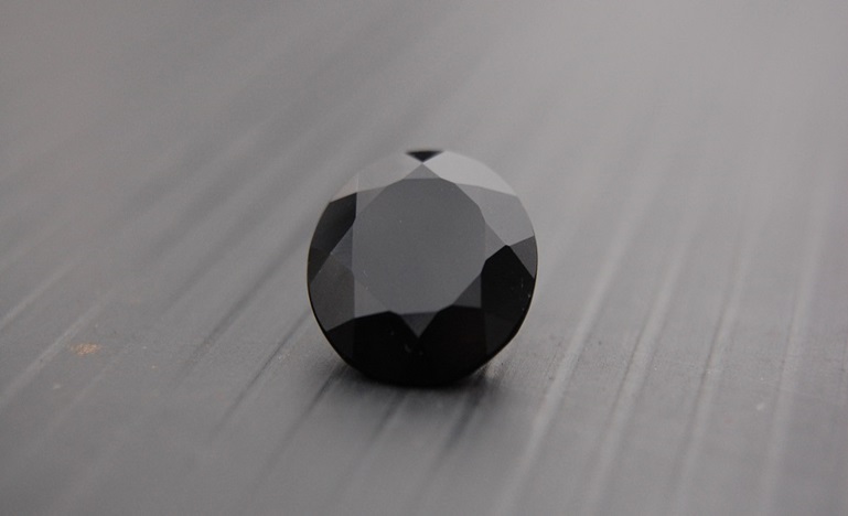 Black gemstone on a gray surface