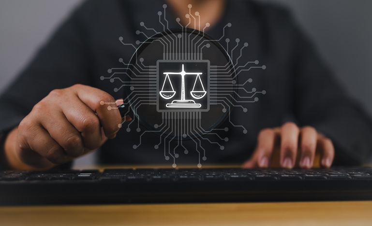 person seated at computer keyboard - only torso and hands are visible - dressed in black with fingers on keyboard and illustration of scales of justice floating above keyboard