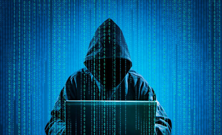 Hooded figure at laptop with coding coming down like rain