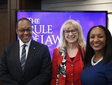 A Photo of The Honourable Michael Tulloch standing next to OBA Past-President Lynne Vicars and OBA member Sojourner King at the Rotary Club of Toronto, in front of a screen that says The Rule of Law